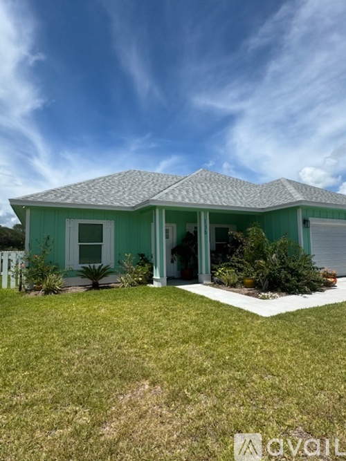 A house with a green roof and white trim is shown.