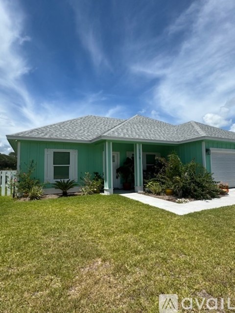 A house with a green roof and white trim is shown.