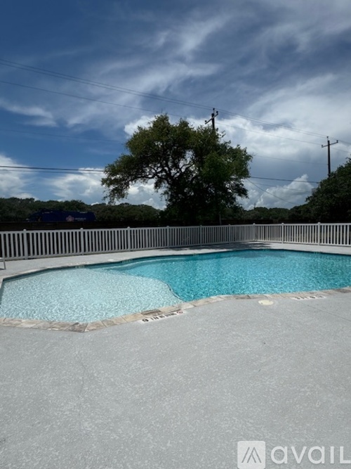 A pool with a grey edge and blue water under a cloudy sky.