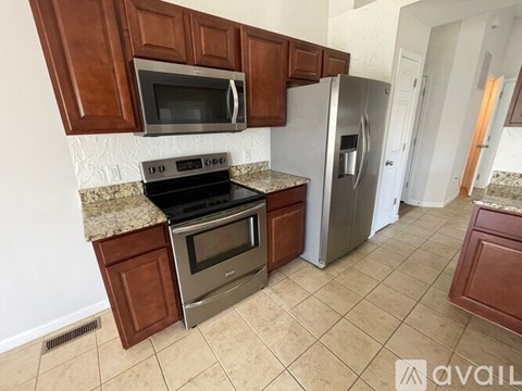 A kitchen with brown cabinets and a stainless steel refrigerator.