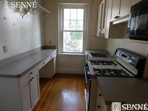 A kitchen with a stove and a window.