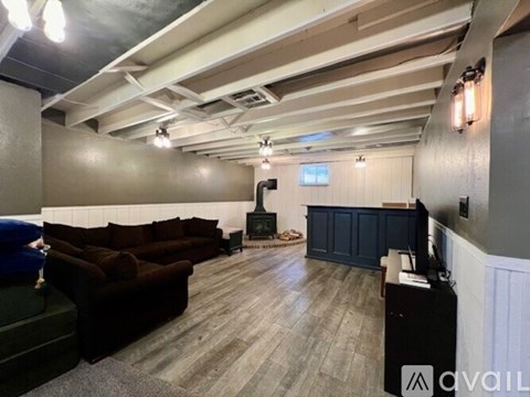 A living room with a dark brown couch and a television.