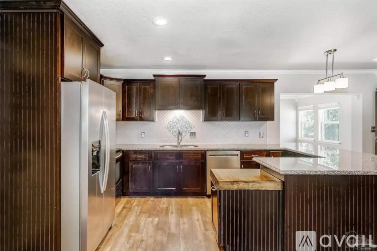 A modern kitchen with dark wood cabinets and a white refrigerator.