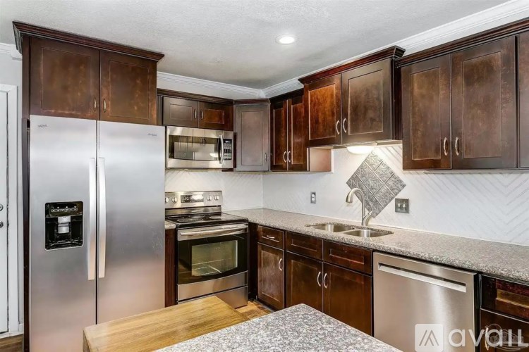A kitchen with dark wood cabinets and stainless steel appliances.