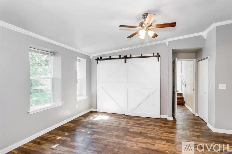 A room with a sliding door and a ceiling fan.
