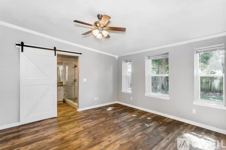 A room with a ceiling fan and a sliding door.