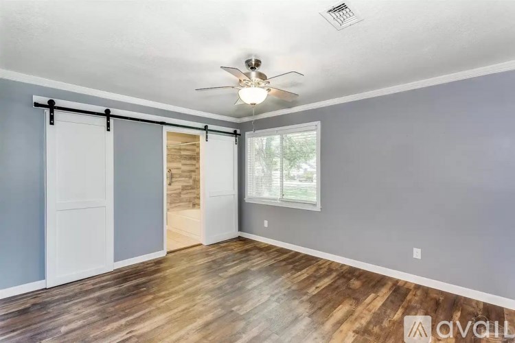 A room with a sliding door and a ceiling fan.