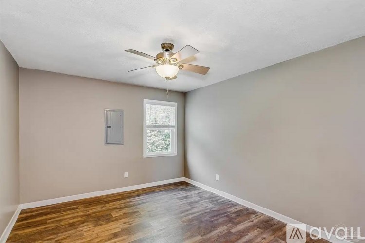 A room with a ceiling fan and a window.