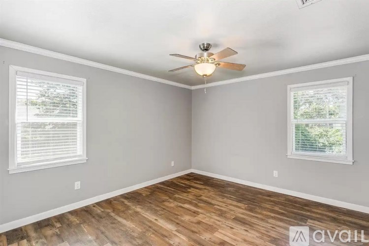 A room with wooden floors and a ceiling fan.