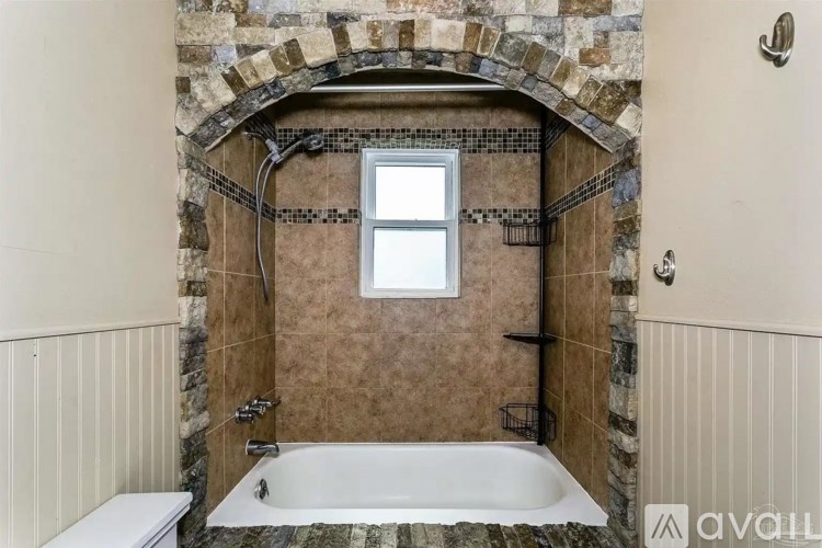 A bathroom with a stone archway and a bathtub.