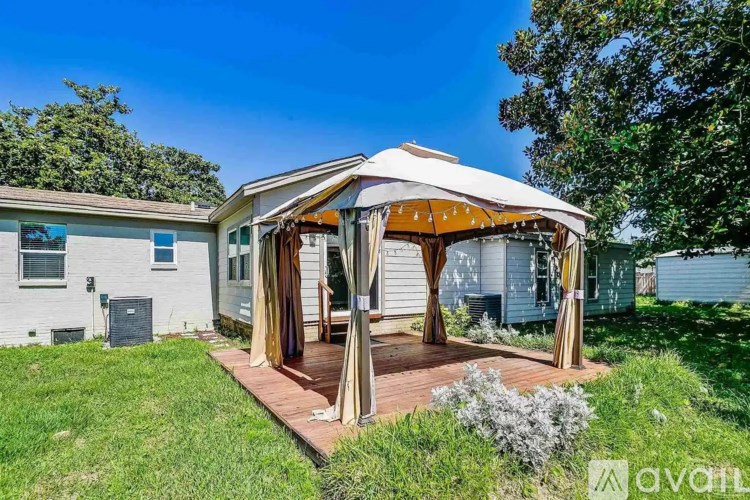 A white house with a gazebo in front of it.