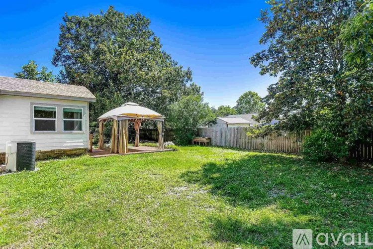 A backyard with a gazebo and a fence.