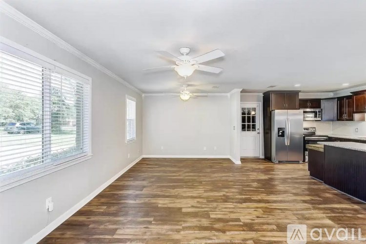 A kitchen with a refrigerator, cabinets, and a ceiling fan.