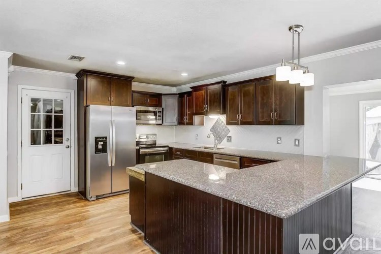 A kitchen with a granite countertop and stainless steel appliances.