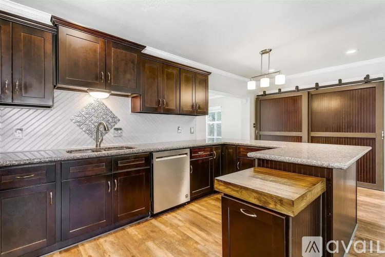 A kitchen with dark wood cabinets and a white countertop.