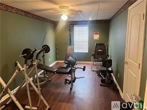A home gym with a variety of equipment including a weight bench, a leg press machine, and a squat rack.