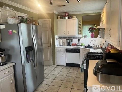 A kitchen with a refrigerator, oven, and sink.