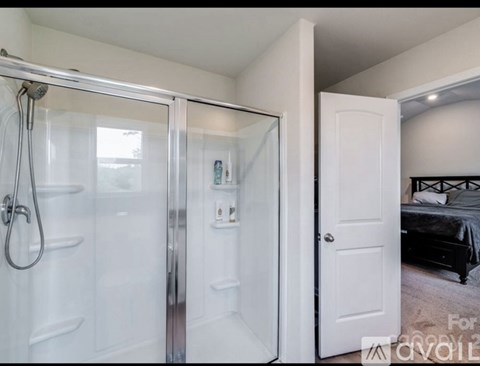 A bedroom with a bed, a shower, and a toilet.
