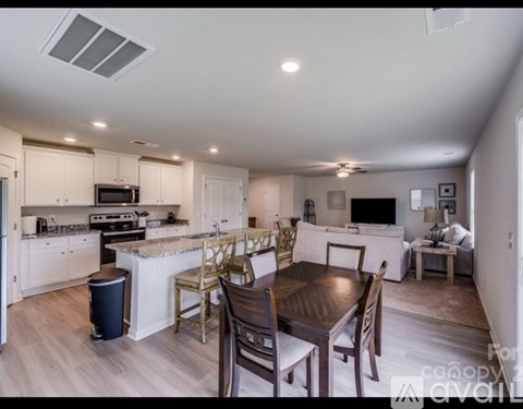 A well-lit, spacious kitchen and dining area with modern furniture.
