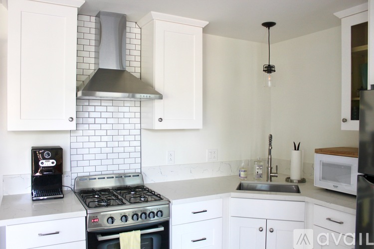A kitchen with a stove, oven, and white cabinets.