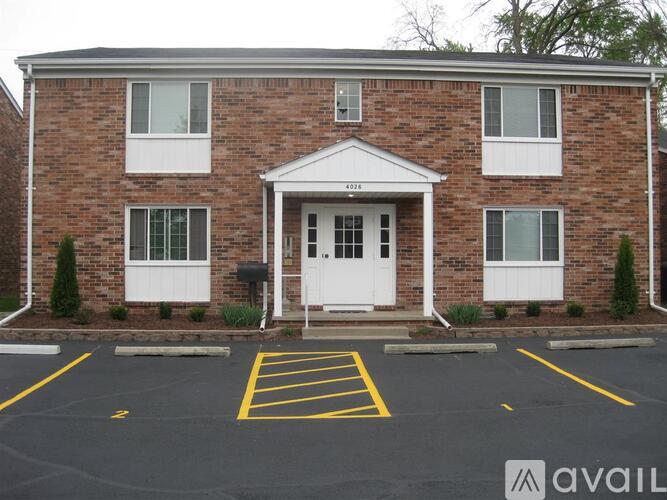 A brick building with a white door and windows.
