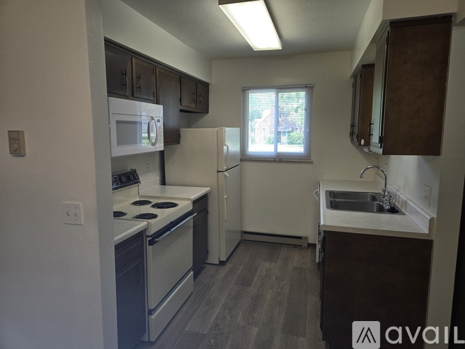A kitchen with a stove, refrigerator, and sink.