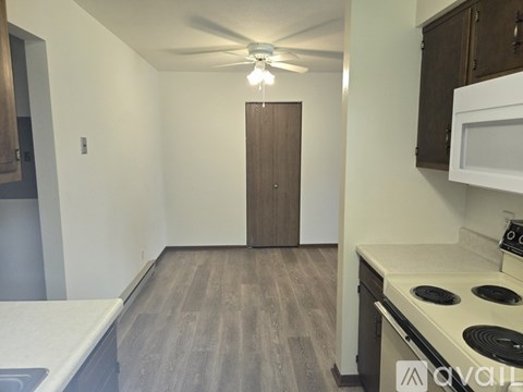 A kitchen with a white countertop and a white stove top oven.