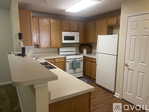 A kitchen with wooden cabinets and white appliances.