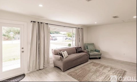 A living room with a grey couch and a green armchair.