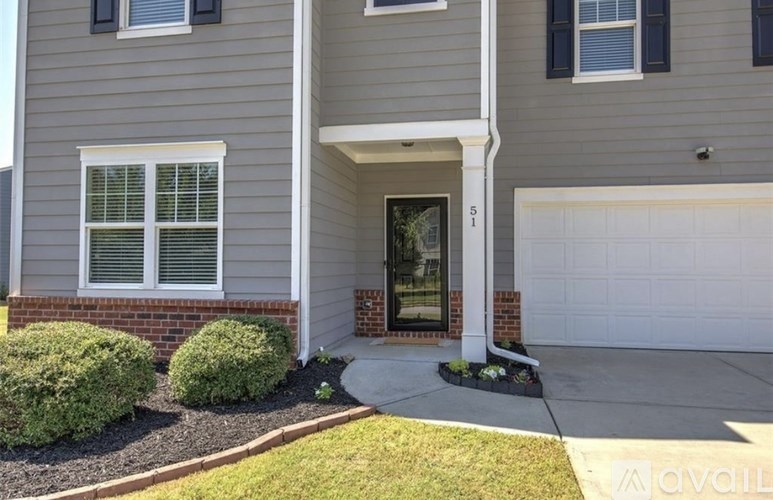 A house with a grey siding and a white garage door.