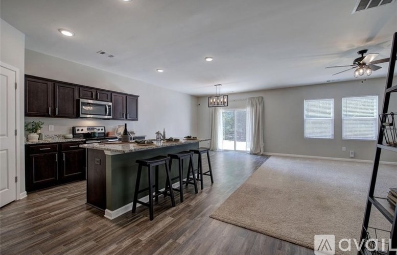 A kitchen with dark brown cabinets and a bar area with stools.