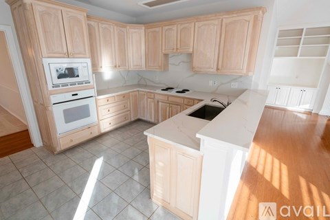 A kitchen with wooden cabinets and a white countertop.