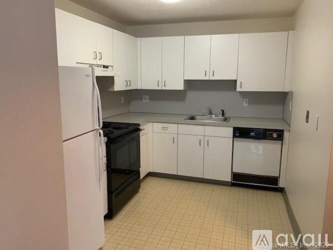 A kitchen with white cabinets and appliances.