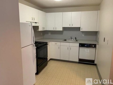 A kitchen with white cabinets and appliances.