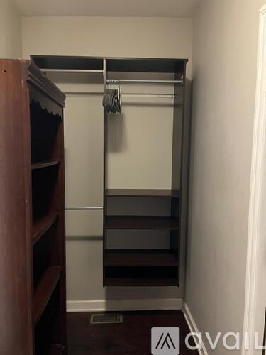 A small closet with a metal rod and shelves.
