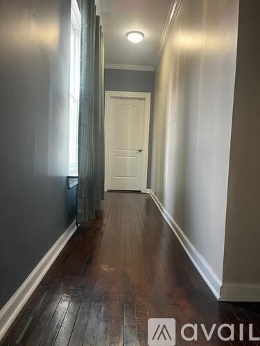 A hallway with a white door at the end.