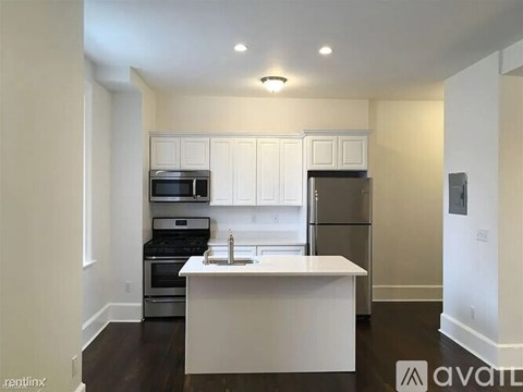 A kitchen with white cabinets and appliances.