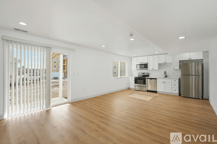 A spacious kitchen with wooden floors and stainless steel appliances.