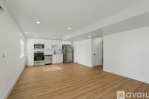 A kitchen with white cabinets and a wooden floor.