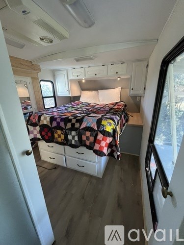A bedroom with a bed covered in a patchwork quilt is shown.