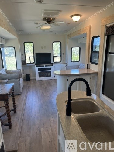 A kitchen area with a sink and a refrigerator in a house.