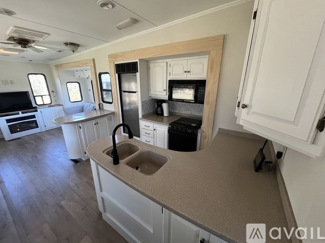 A kitchen area with a sink, stove, and refrigerator.
