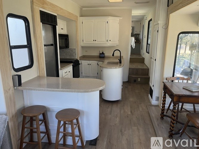 A kitchen area with a counter and bar stools.