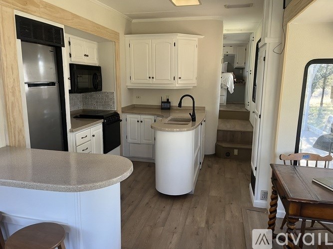 A kitchen with a refrigerator, microwave, and cabinets.