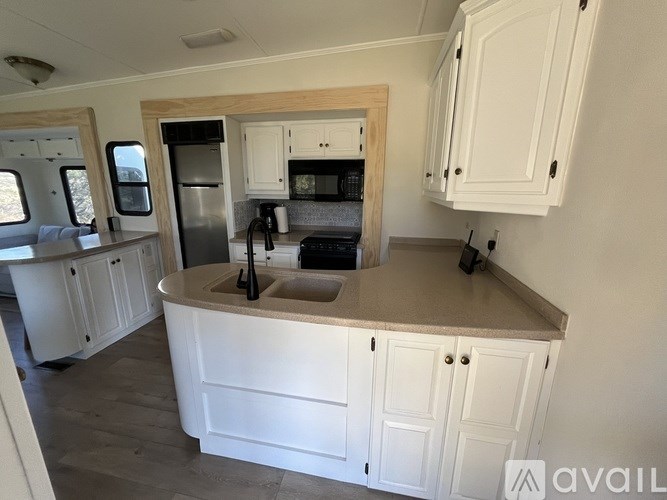 A kitchen with white cabinets and a wooden island.