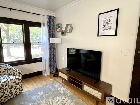 A living room with a television and a patterned chair.