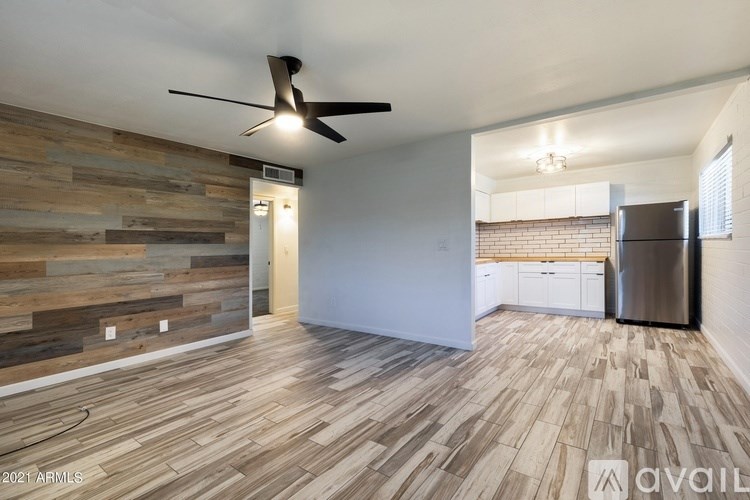 A room with wooden flooring and a ceiling fan.