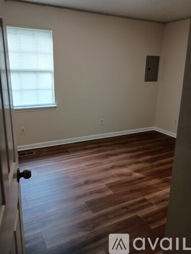 A kitchen with a white door and wooden cabinets.