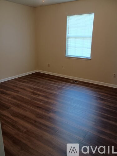 A hallway with a door on the left and a wall-mounted air conditioner on the right.