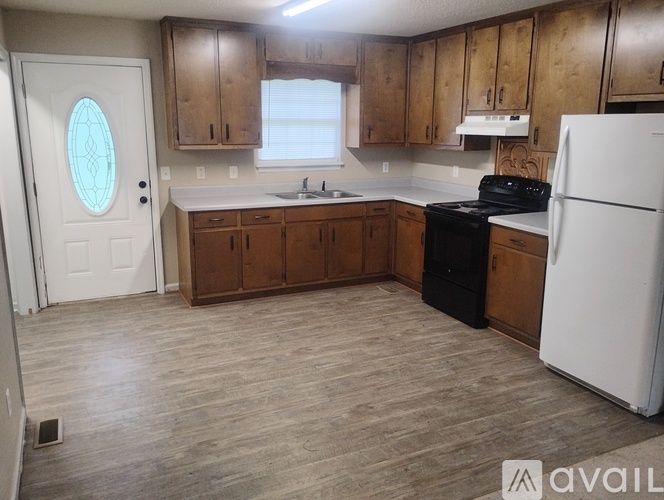 A kitchen with wooden cabinets and a white refrigerator.